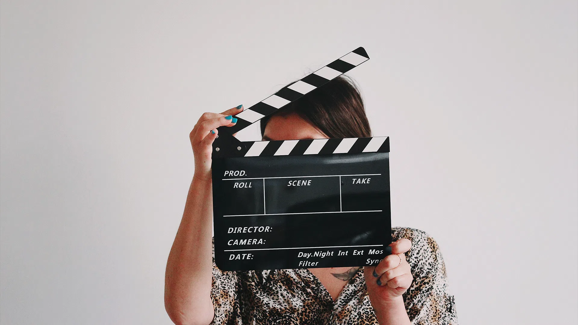 Marketer holding a film clapperboard, highlighting the role of video advertising in modern marketing strategies.